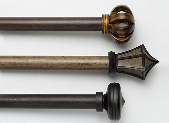 Three drapery hardware options in various Bowery finishes laid out on a white table top