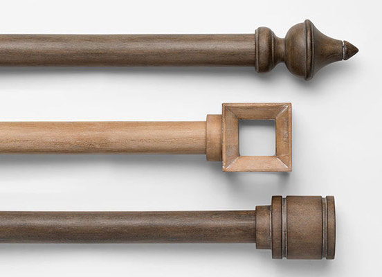 Three drapery hardware options in various Lenox finishes laid out on a white table top