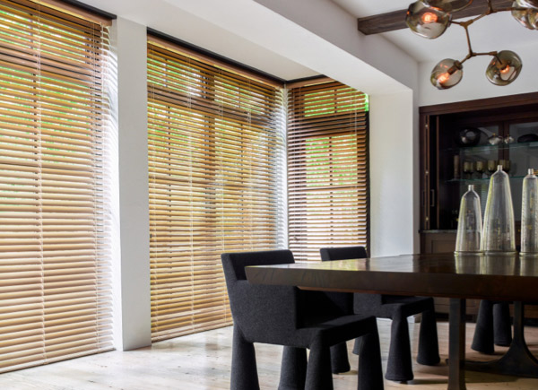 Floor to ceiling windows featuring metal blinds in 2 inch champagne in a dining room with a large dark table and black chairs