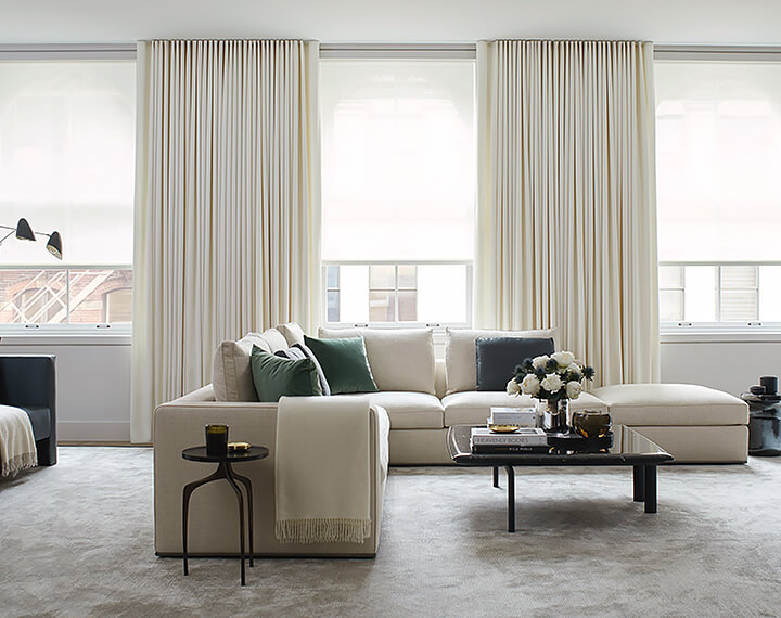 Window curtains for living room spaces in a soft neutral fabric bring a polished look to a bright, elegant room.