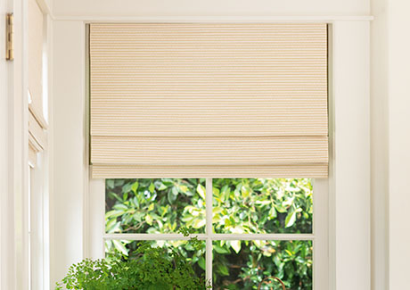 One of today's popular window covering ideas and trends is the use of artisan weaves seen on these Woven Wood Shades in a dining room