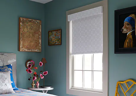 A turquoise bedroom features privacy shades in a Roller Shade style made of blackout Porringer material in Sand for bedroom window coverings and nighttime privacy
